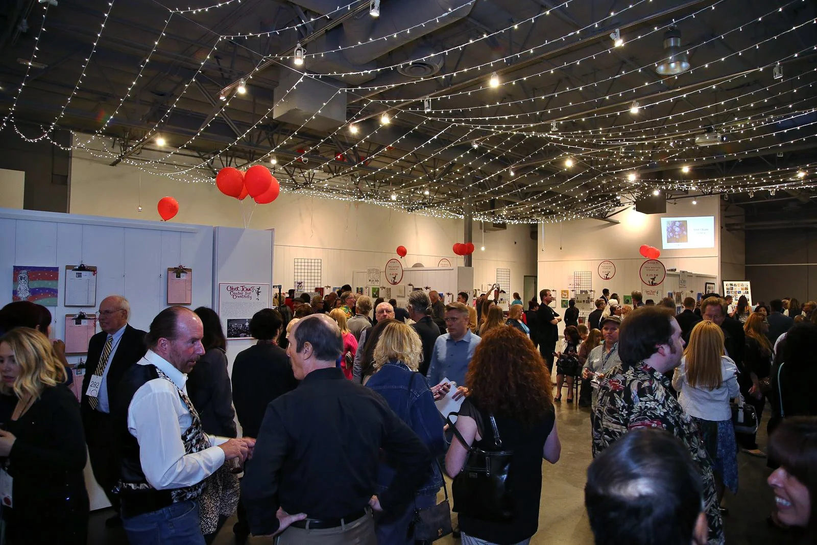Guests browsing anonymous artwork at the Red/Dot Auction